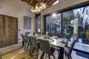 comedor con mesa y sillas y ventana grande en Chalet Silver Forest en Chamonix-Mont-Blanc