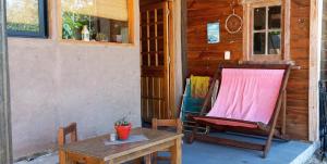 a rocking chair and a table on a porch at Calma in Cuchilla Alta