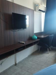 um quarto com uma televisão numa parede de madeira em VILLA DEL SOL Hotel em Fortaleza