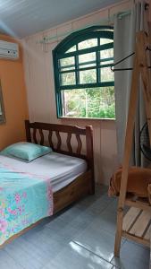 a bedroom with a bed and a window at Pousada e Camping da Rhaiana - Ilha do Mel - PR in Ilha do Mel