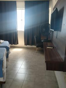 um quarto com uma cama e uma secretária com uma ventoinha em VILLA DEL SOL Hotel em Fortaleza