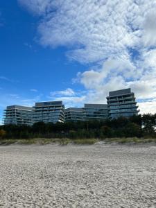 WAVE 10th Floor Baltic View في مينززدرويه: مبنيان على الشاطئ أمام شاطئ رملي