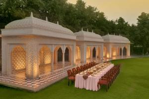 una mesa larga en un cenador con mesas y sillas en Heritage Village Resort & Spa Manesar-Gurgaon en Gurgaon