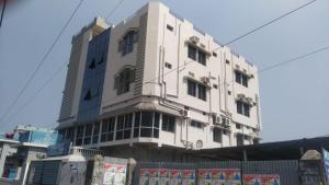 a white building with a fence in front of it at HOTEL OASIS PALACE in Dālkola