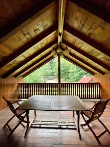 una mesa y 2 sillas frente a una gran ventana en Casa Fenyves Vendégház, en Băile Tuşnad