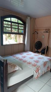 Cama en habitación con ventana en Pousada e Camping da Rhaiana - Ilha do Mel - PR, en Ilha do Mel