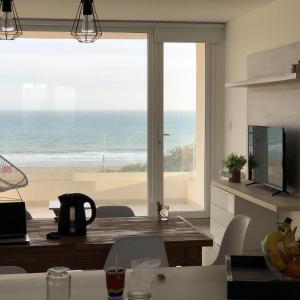 eine Küche mit Tisch und Blick auf das Meer in der Unterkunft Carpe Diem Monte Hermoso in Monte Hermoso