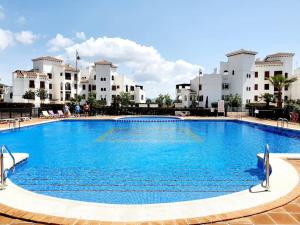 ein großer blauer Pool vor den Gebäuden in der Unterkunft Ptabaja. a pie de piscina en el Valle Golf Resort in Murcia