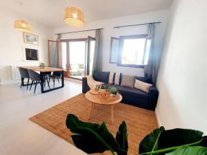 ein Wohnzimmer mit einem Sofa und einem Tisch in der Unterkunft Ptabaja. a pie de piscina en el Valle Golf Resort in Murcia