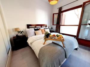 ein Schlafzimmer mit einem Bett und einem Tablett mit Essen drauf in der Unterkunft Ptabaja. a pie de piscina en el Valle Golf Resort in Murcia