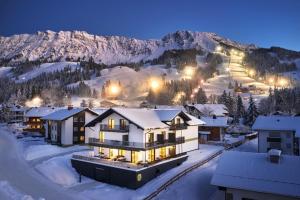 a house in the snow at night with mountains at BergBuddies - Übernachtung inklusive kostenlosen Bergbahntickets und vielem mehr in Bad Hindelang