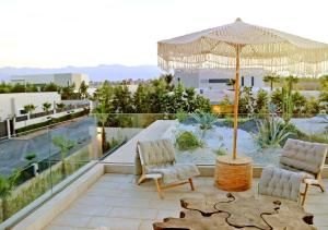 a patio with two chairs and an umbrella on a roof at Villa Amber in Marrakech