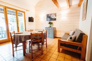 a dining room with a table and a couch at Chalets et gîtes d'Orlu in Orlu