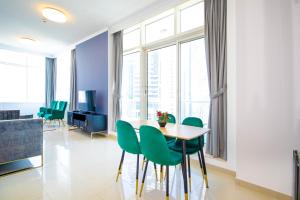a dining room with a table and green chairs at Modern Sea View 1Bedroom Dubai Marina in Dubai