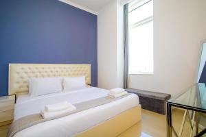a bedroom with a large bed with a blue wall at Modern Sea View 1Bedroom Dubai Marina in Dubai