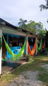 a house with hammocks hanging from the front porch at Pousada e Camping da Rhaiana - Ilha do Mel - PR in Ilha do Mel