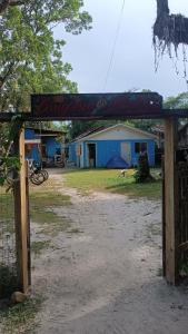 una valla con una señal frente a un edificio en Pousada e Camping da Rhaiana - Ilha do Mel - PR, en Ilha do Mel