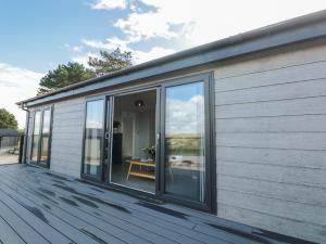a house with sliding glass doors on a deck at Bluebell Lodge in Dartmouth