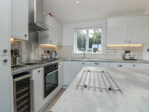 a kitchen with white cabinets and a white counter top at Bluebell Lodge in Dartmouth