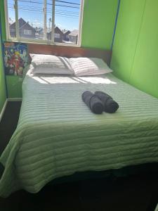 a bed with two towels on it with a window at Casa Her Pto Montt 3Dorm in Llanquihue
