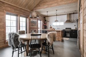una cocina con mesa y sillas con piel en Luxurious cottage with sauna overlooking mountains en Vemdalsskalet