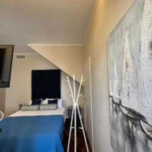 Habitación con cama y pintura en la pared en ComeCasa Larga Cosy Studio en Milán
