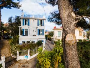 a white house with a tree in front of it at Hotel Albert 1er in Cannes