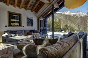 a living room with couches and a large window at Chalet Silver Forest in Chamonix-Mont-Blanc