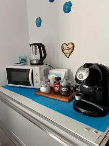 encimera de cocina con cafetera y microondas en Il Focolare Casa Vacanza, en Torchiarolo