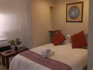 Habitación de hotel con 2 camas y mesa en Yacht View Lodge, en Schoemansville