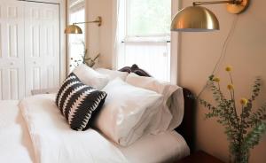 een witte bank met kussens in een kamer met een raam bij Cozy Artist's Cottage-3br, Dt, Uga, Classic Cent in Athens