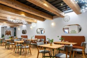 un restaurante con mesas de madera, sillas y espejos en Pipitér Rooms & More, en Szigliget