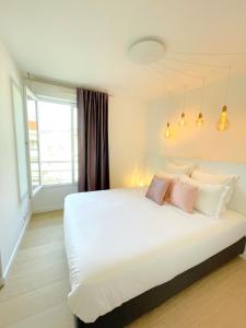 a bedroom with a large white bed with pink pillows at Alba DeLuxe - 3 Bedroom Pointe Croisette, by Welcome to Cannes in Cannes