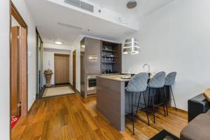 a kitchen with a counter and bar stools at High-Rise Amazing View Apartment 14th Floor In CityCentre in Tallinn