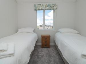 two beds in a room with a window at Honeysuckle Lodge in Dartmouth +12 photos