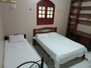 2 camas en una habitación con sábanas blancas en Chácara Calixto, en Belém