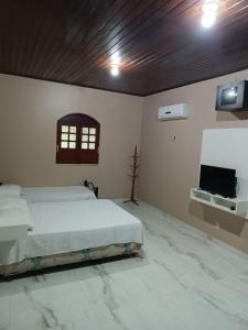 1 dormitorio con 1 cama y TV de pantalla plana en Chácara Calixto, en Belém