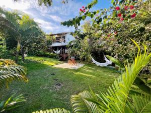 un giardino con una casa sullo sfondo di Casa com piscina e vista para a Praia do Espelho a Porto Seguro
