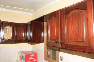 a kitchen with wooden cabinets on the wall at Ramos Aparttment in São Filipe