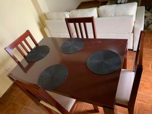 a dining room table with two chairs and a couch at Ramos Apartamento in São Filipe