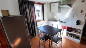 a small kitchen with a table and a refrigerator at Rústico Punucapa in Valdivia