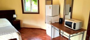 バルディビアにあるRústico Punucapaの電子レンジ、テーブル、冷蔵庫が備わる客室です。