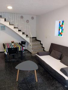 a living room with a couch and a staircase at La playa in L'Escala