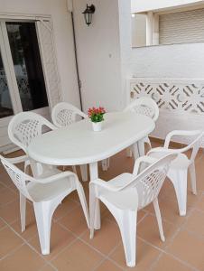 een witte tafel en stoelen op een patio bij La playa in L'Escala