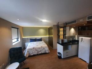 1 dormitorio pequeño con 1 cama y cocina en FLAT HOTEL DOIS QUARTOS AV IBIRAPUERA 2927, en São Paulo