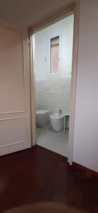 bagno bianco con servizi igienici e finestra di Center rooms Bartolini a Bologna