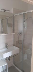 bagno bianco con lavandino e doccia di Center rooms Bartolini a Bologna