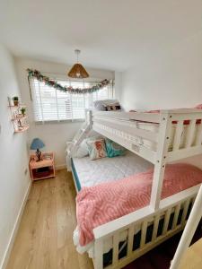 a bedroom with two bunk beds and a window at 288, Belle Aire, Hemsby - Beautifully presented two bed chalet, sleeps 5, pet friendly, close to beach! in Hemsby