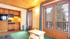 a kitchen with a wooden door and a table at Alpina Lodge 23 - Appt pied des pistes 6 pers in Les Deux Alpes +2 photos