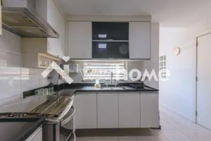 a kitchen with white cabinets and a sink at Charmoso apartamento a 550m da Praia do Flamengo in Rio de Janeiro